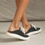 Reef Neptune footwear facing left, showing black breathable knit upper with cushioned sole and easy slip-on design.