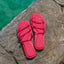 Willow Ava-Rose women's red sandals viewed from above showing straps and cushioned footbed on rock by water.