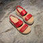 Pair of red Water Vista Higher sandals for women facing upward, showing straps and cushioned footbed on rock surface.