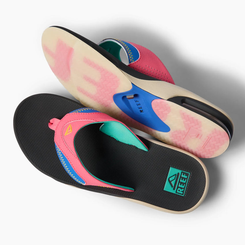 Pair of Fanning flip flops showing top view and sole with pink, blue, and black water-friendly design facing right