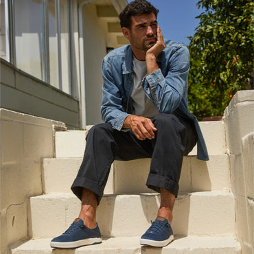 Laguna blue sneakers facing forward on a man seated outdoors for everyday comfort