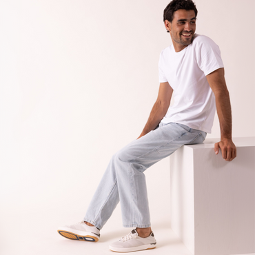 Laguna white sneakers on a seated man, both shoes facing left, offering lightweight comfort for everyday wear