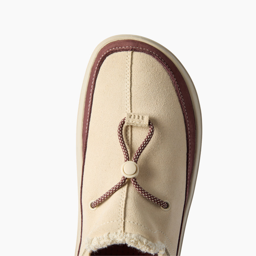 Rambler slipper with toe facing upward, close-up of suede upper and adjustable toggle for cushioned comfort