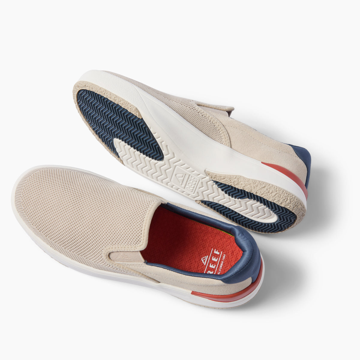 Pair of beige slip-on shoes facing left, showing textured outsoles and cushioned footbeds against a white background