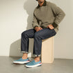 Del Mar Slip On blue slip on sneakers facing left on a seated man with cushioned soles