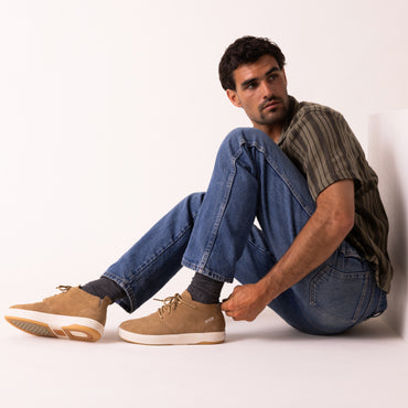 Del Mar Desert tan leather and suede shoes facing left on a seated man with easy entry heels and cushioned comfort