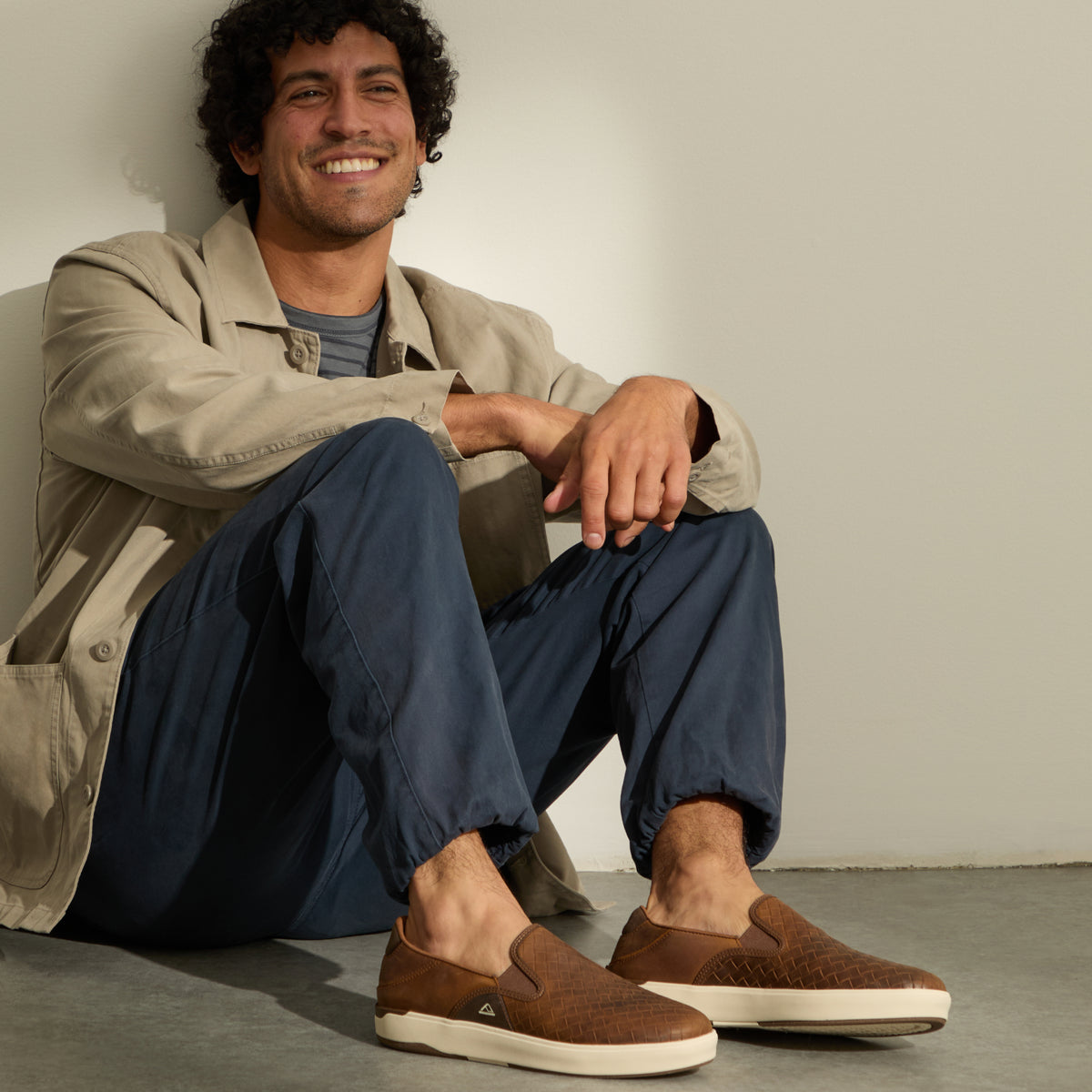Laguna Slip On brown slip on shoes facing toward the viewer on a seated man