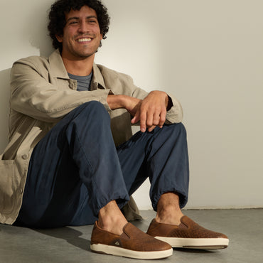 Laguna Slip On brown slip on shoes facing toward the viewer on a seated man