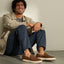 Laguna Slip On brown slip on shoes facing toward the viewer on a seated man