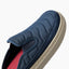 Navy slip-on shoe facing upper right, close-up of quilted upper, side profile, and textured cushioned sole