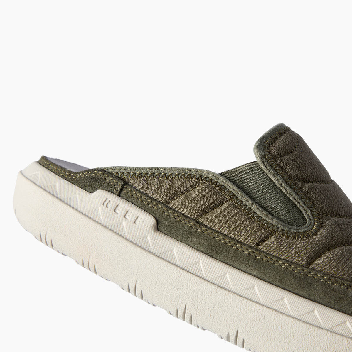 Close-up side view of olive green footwear facing left, with a padded upper and textured cream sole