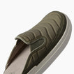 Olive slip on shoe facing upper right with a close up of its padded quilted upper and textured sole