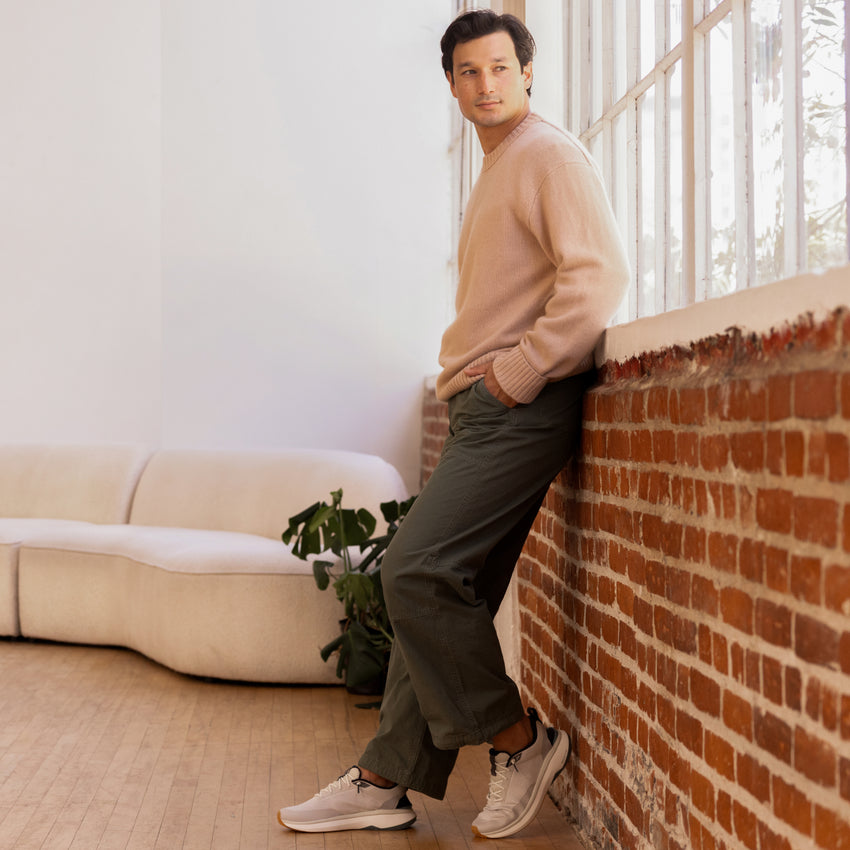 Zuma sneakers facing left on a man indoors, featuring cushioned knit uppers and everyday comfort