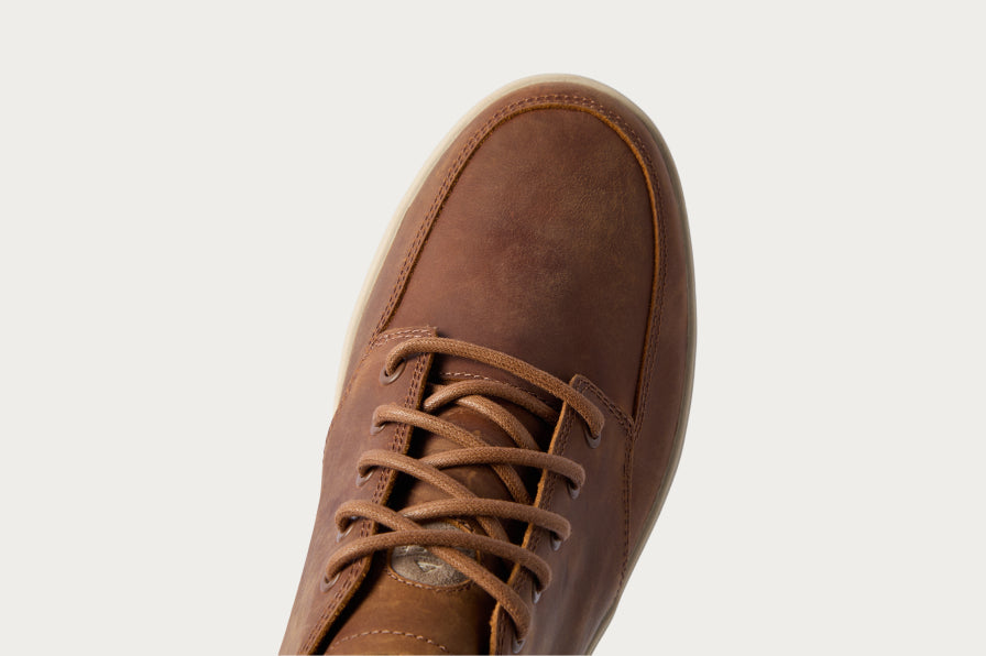 Close-up of a brown lace-up shoe facing upper right, showing the toe box and laces