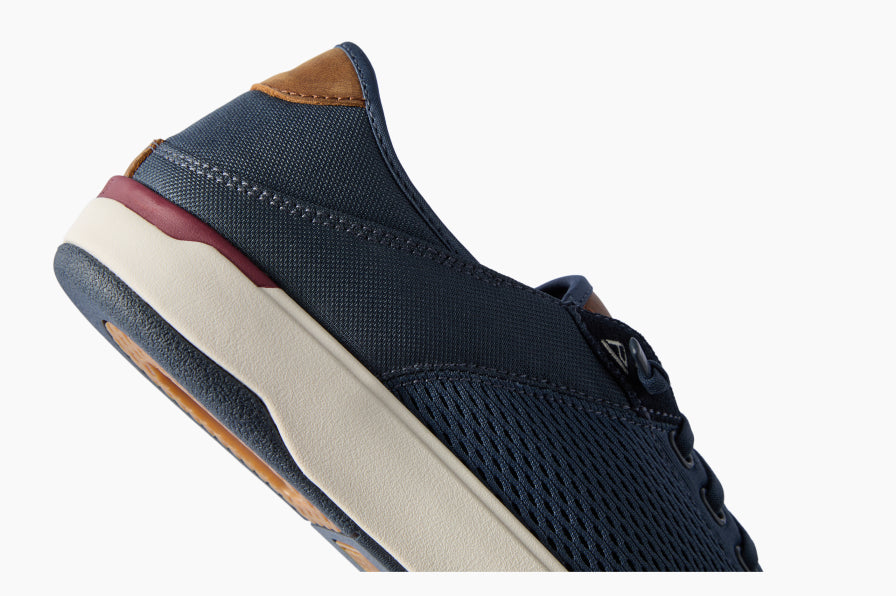 Close-up side view of a dark blue sneaker facing right, with a cushioned cream midsole and brown heel detail