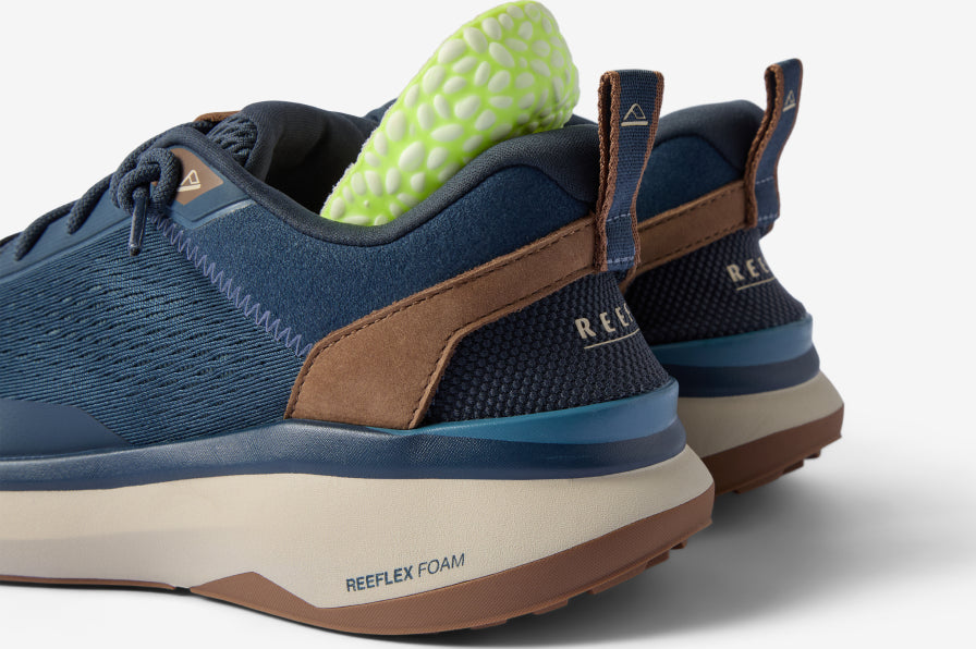 REEF sneakers facing left, shown from the rear with cushioned soles and green textured insoles