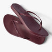 Pair of burgundy Cushion Slim flip flops with slim vegan leather straps shown from top and side angles, right facing sandal on top