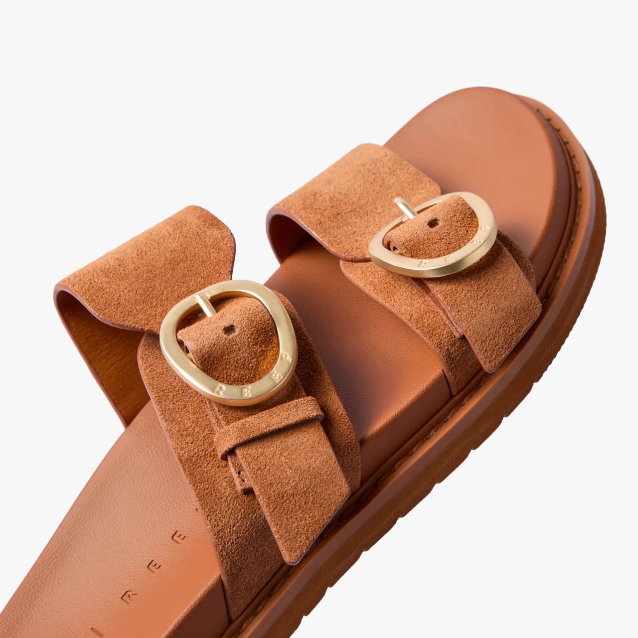 Vista Daphne slide sandal facing right, close-up of sculpted suede straps with gold adjustable buckles