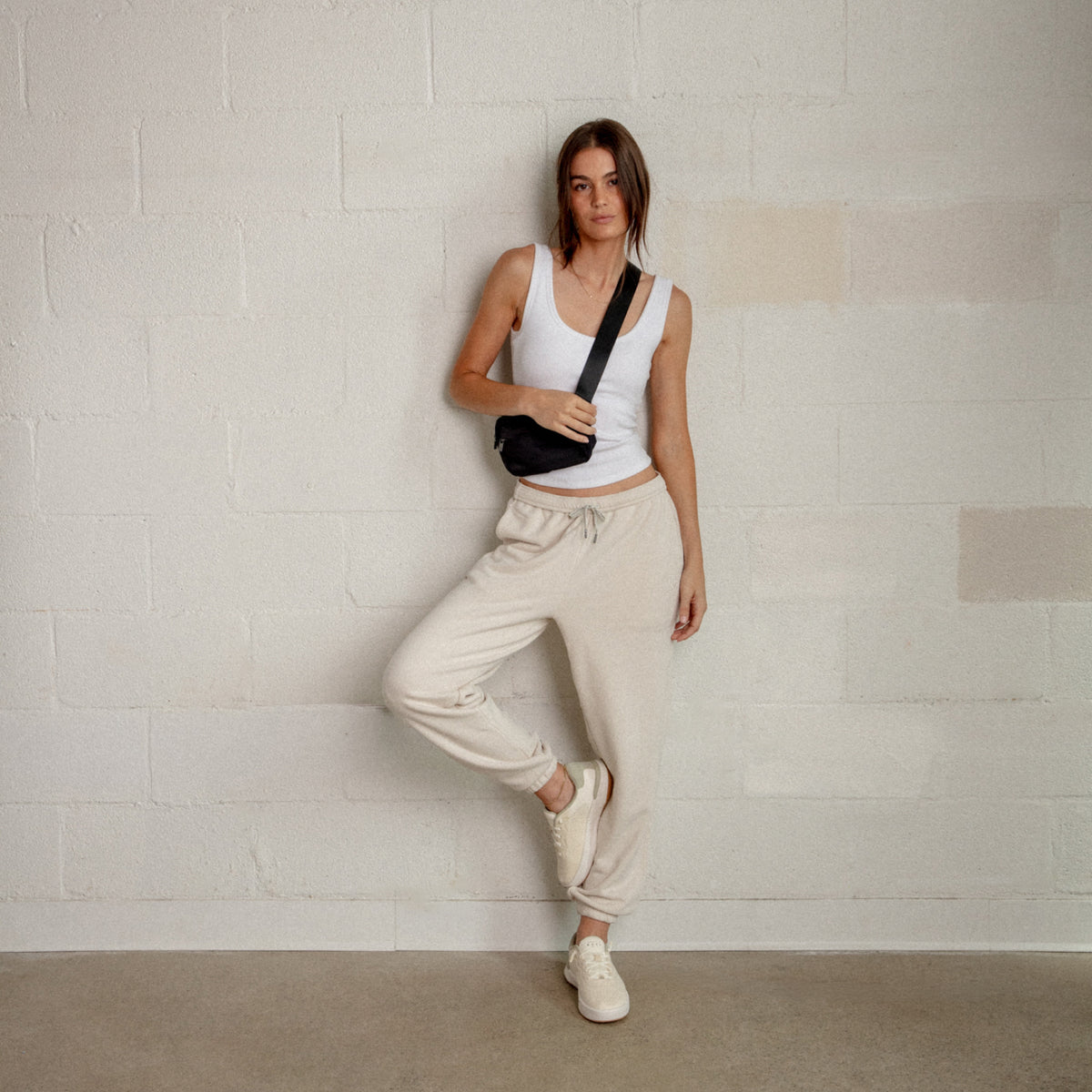 Reef Del Mar cream sneakers facing forward on a woman in a casual travel outfit