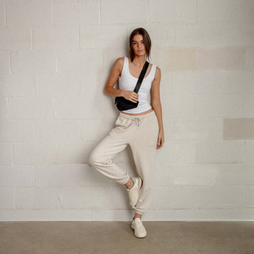 Reef Del Mar cream sneakers facing forward on a woman in a casual travel outfit