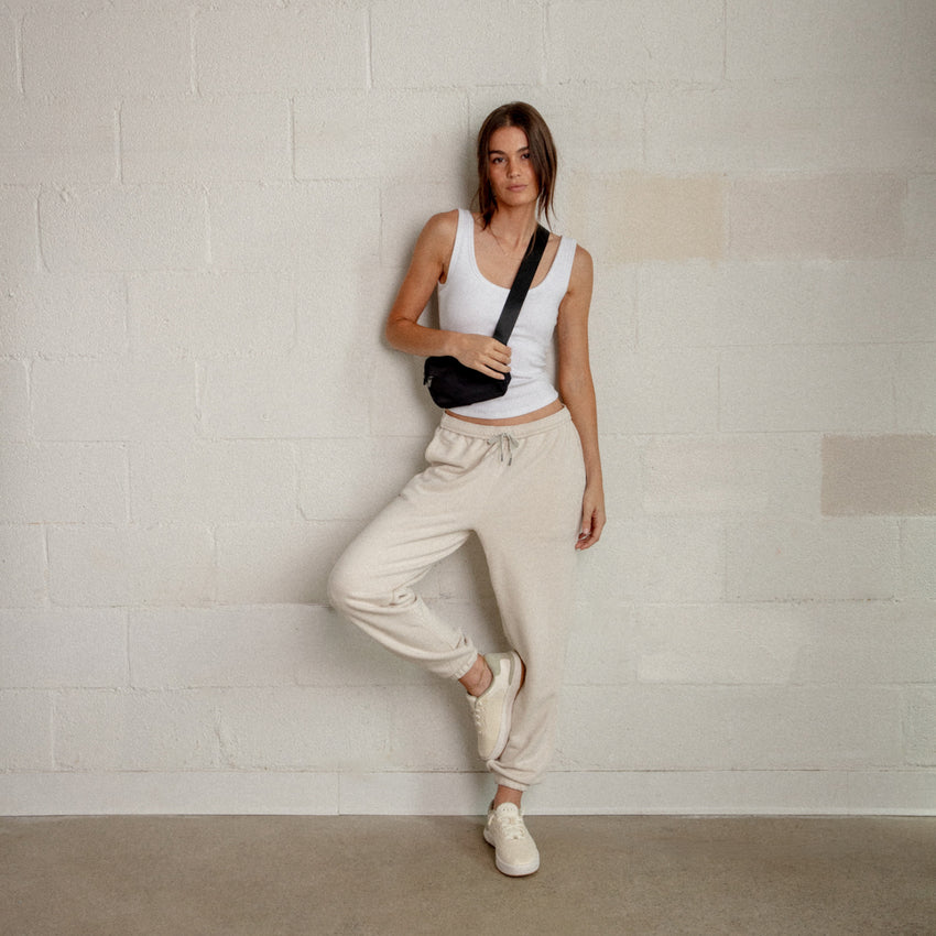 Reef Del Mar cream sneakers facing forward on a woman in a casual travel outfit