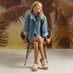 Vista Marbella white three strap sandals facing forward on a seated woman with cushioned arch support for beach ready comfort