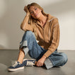 Lay Day Lite navy sneakers facing left on a seated woman, featuring cushioned soles for everyday comfort