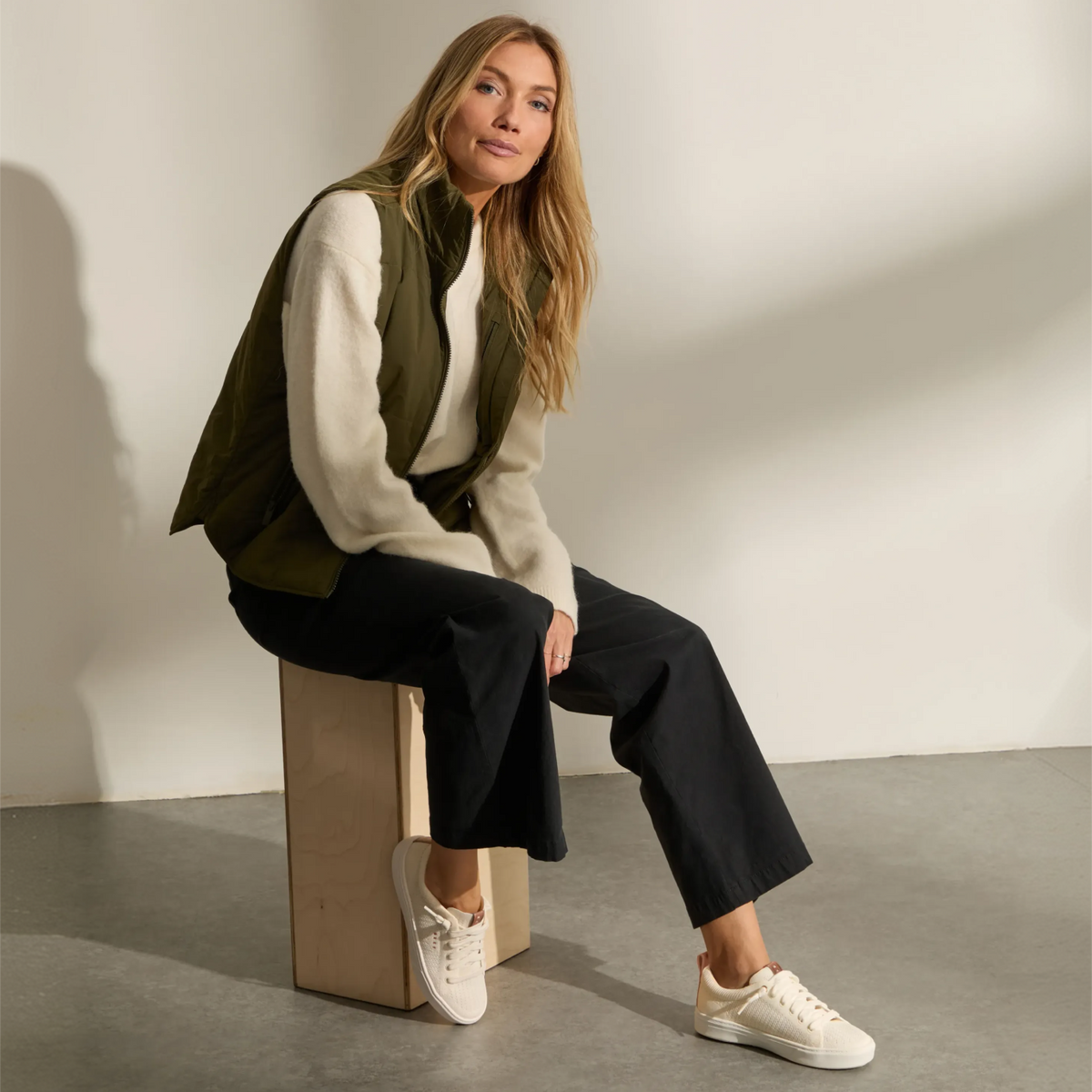 REEF Lay Day Lite white sneakers worn by a seated woman, toes angled forward for everyday comfort