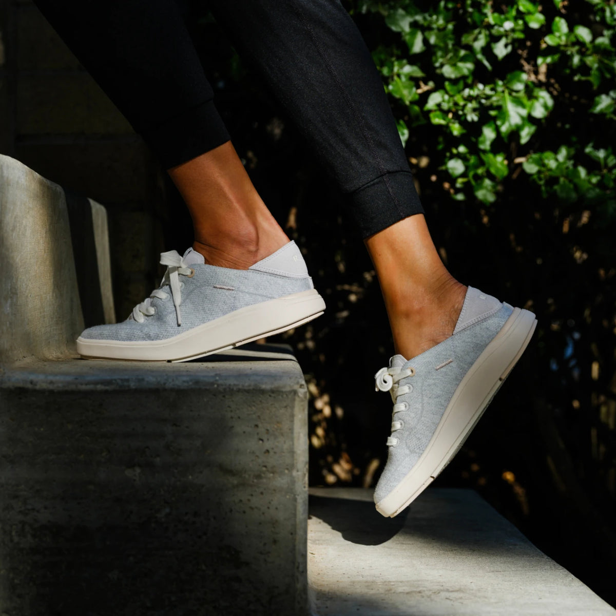 REEF Neptune 2 gray sneakers facing left on outdoor steps, showcasing lightweight comfort and arch support
