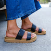 Vista Hi 2 black platform sandals facing right, styled with a denim skirt for everyday comfort