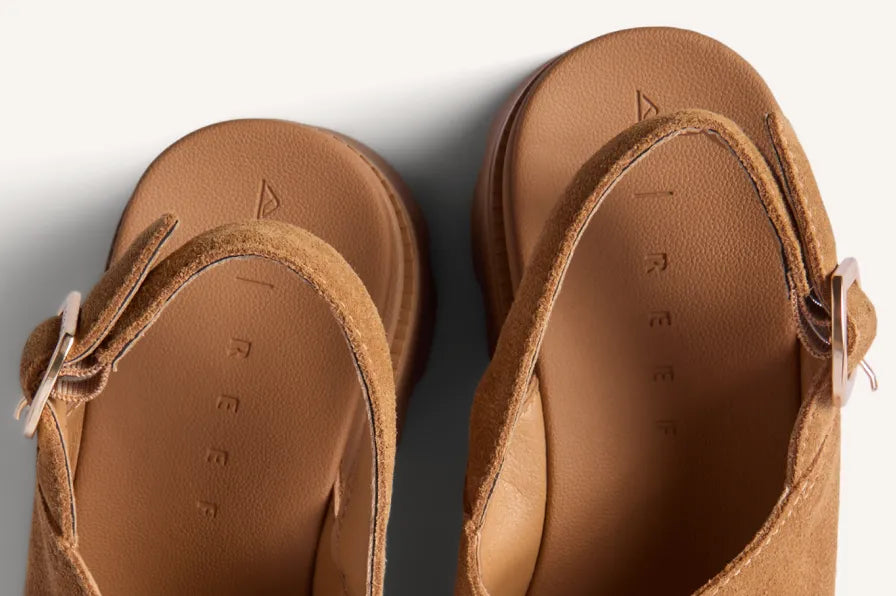 Pair of tan sandals viewed from above, toes facing downward, with cushioned footbeds and adjustable side straps