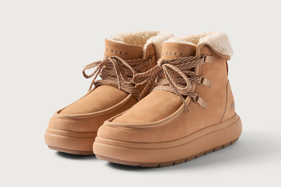 Pair of tan suede boots facing forward left, with plush shearling lining and reinforced stitching for durable comfort.