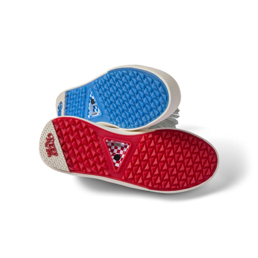 Onshore Pebble X Palm men's shoes soles facing up, showing durable red and blue gripped outsoles for beach comfort.