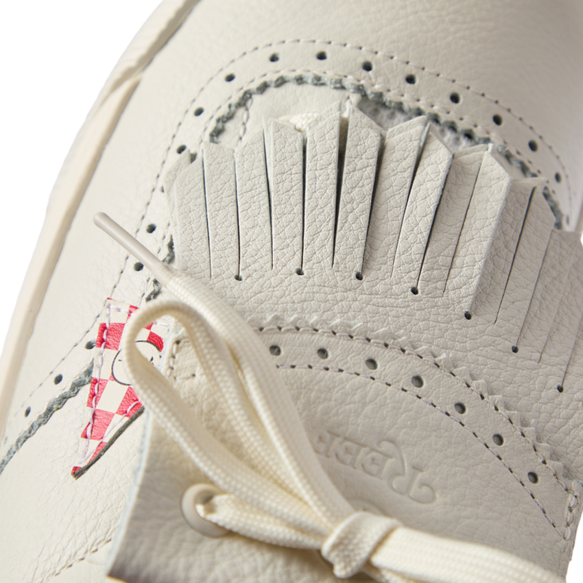 Close-up of the top front of the Onshore Pebble X Palm sneaker in off-white with soft leather and detailed stitching