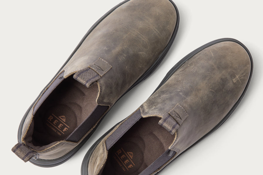 Top view of worn gray REEF slip-on shoes facing upward with anatomical arch support and cushioned insoles visible