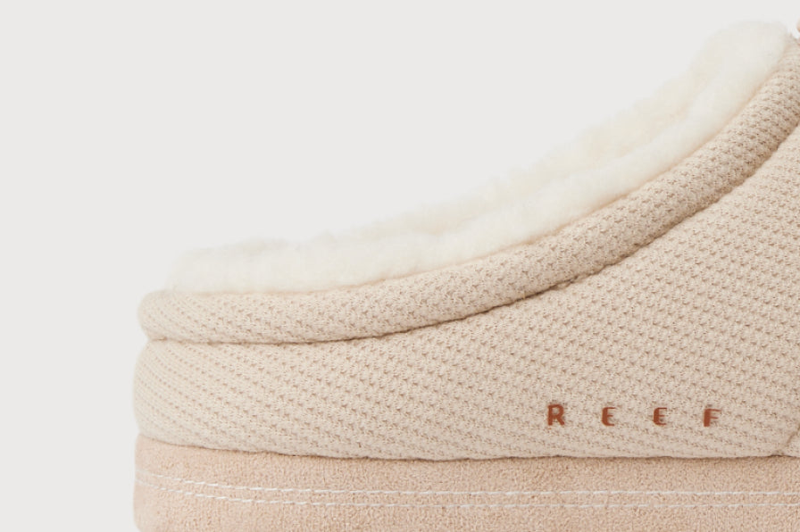 Close-up of the beige heel collar of a REEF shoe with textured fabric and plush lining for cushioned everyday comfort.