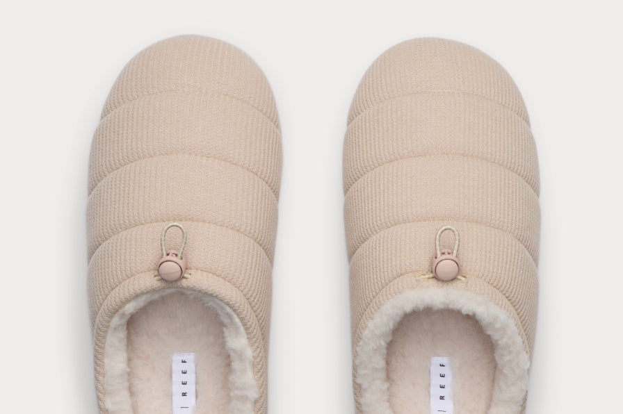 Top view of beige quilted slip-on shoes facing upward with plush fleece lining for lightweight all-day comfort.
