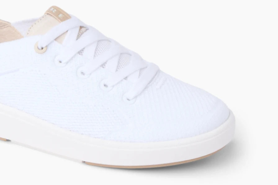 Close-up of a white sneaker facing right, showing its laces, textured upper, and cushioned sole.