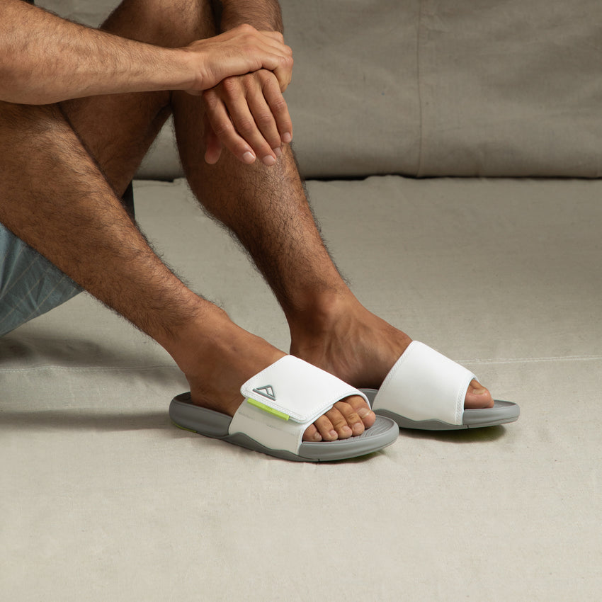 Man wearing Phantom Slab slides facing forward, showing soft white straps and cushioned arch support design.