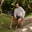 Man sitting outdoors wearing Phantom Tradewind sandals facing forward, showcasing comfort and beach-inspired design.