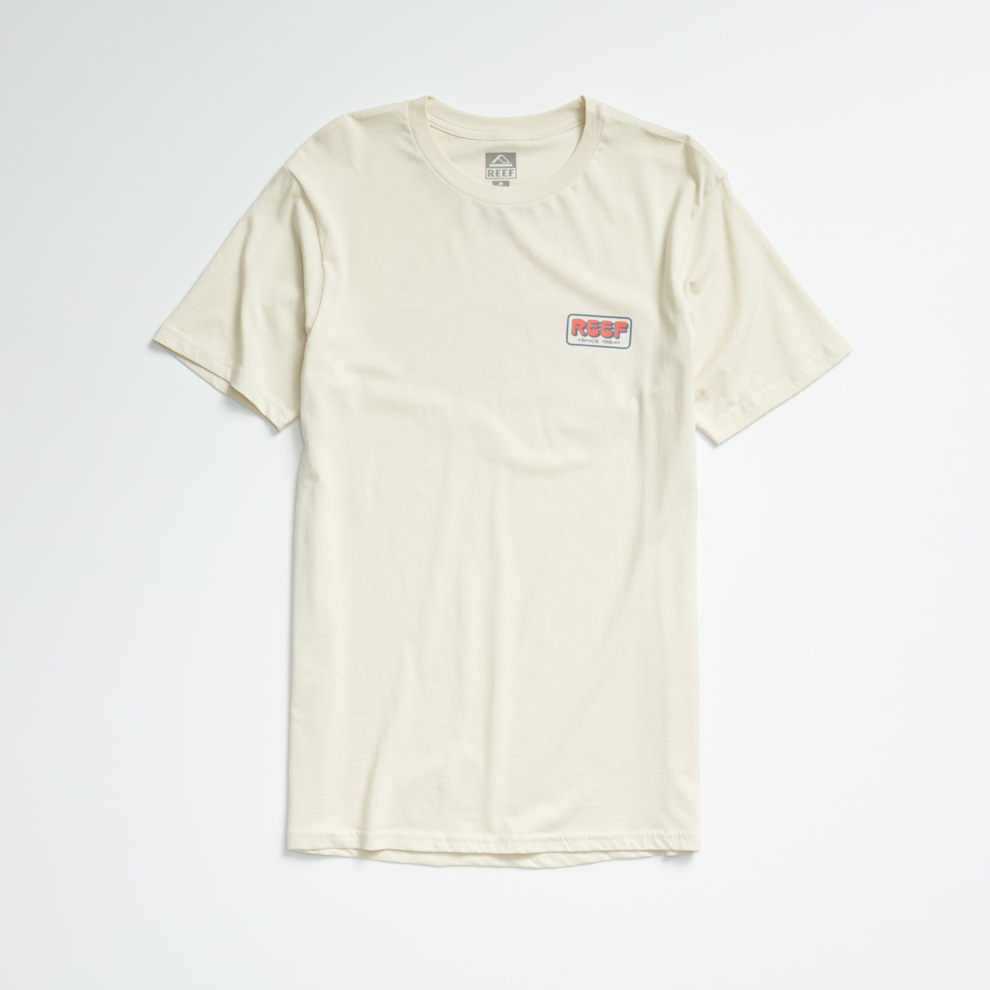 Quinn Tee in almond milk color, laid flat showing front with small REEF logo on chest, lightweight comfort apparel.
