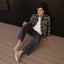 man wearing Rambler Mule Brown and jeans and a flannel sitting outside a cabin
