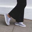 Side view of Reef Neptune lightweight grey women's sneaker with breathable knit upper and cushioned sole on a sidewalk.