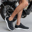 Valle black sneaker facing right, close-up side view on adult man's feet, showcasing soft-rebound cushioning and arch support.