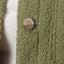 Close-up of olive green Sammie Sherpa Jacket fabric showing texture and REEF metal logo button for comfort-focused beach apparel.