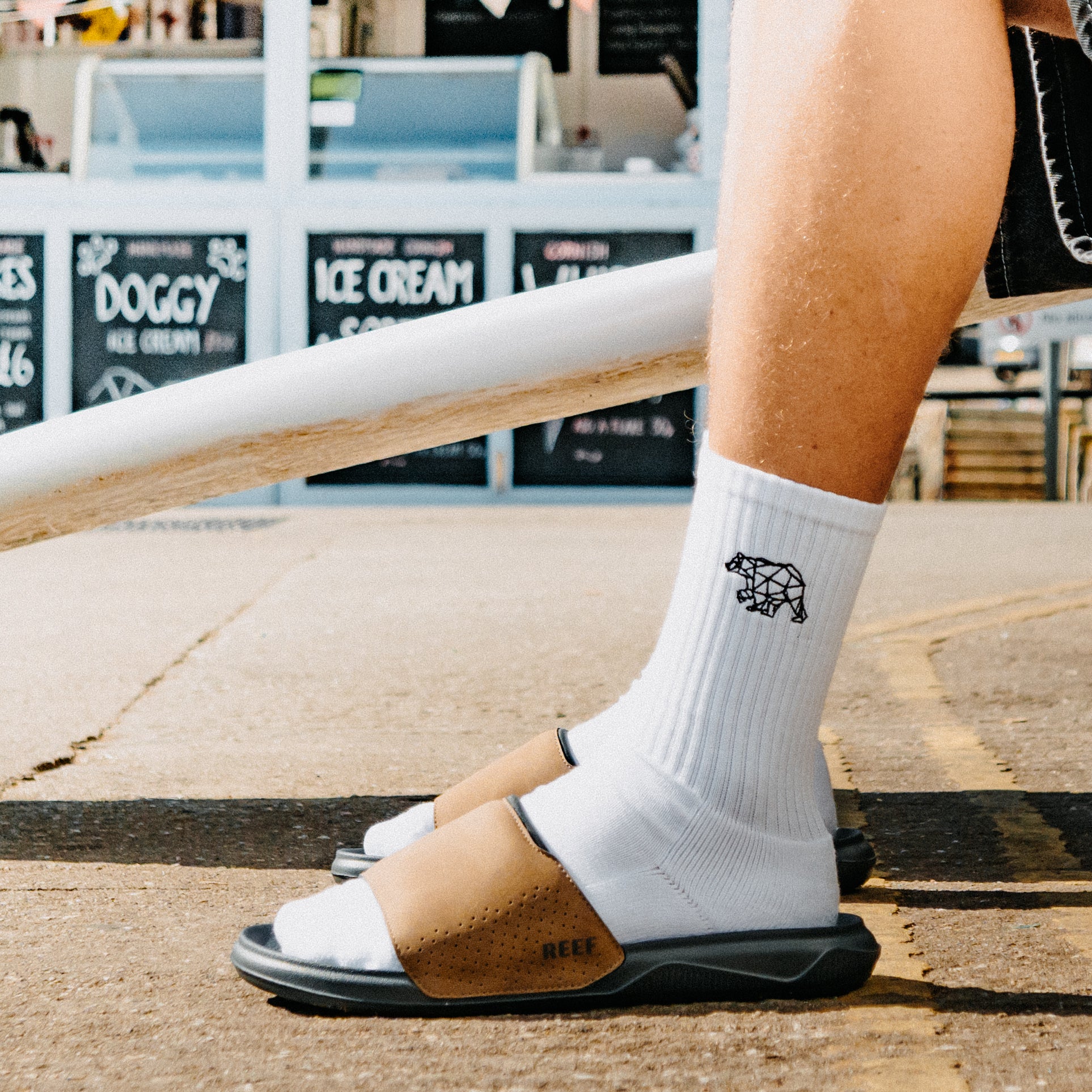 Tailslide mens tan and black slide sandals facing left in side view with a cushioned footbed