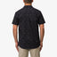 Man wearing the back view of the Topaz Shirt in black with subtle pattern, designed for beach comfort and style.