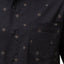 Close-up of the pocket and button area on the men's Topaz Shirt featuring subtle patterned dots on black fabric.