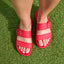 Vista Capri women's red sandals seen from above, front facing, with adjustable buckle straps on grass surface.