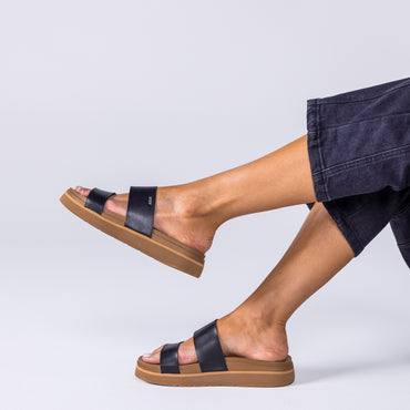 Vista Hi 2 sandal in black facing right, showing side view of cushioned footbed and arch support, worn with casual pants.